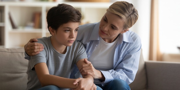 Parent comforting their child on a couch in a supportive atmosphere